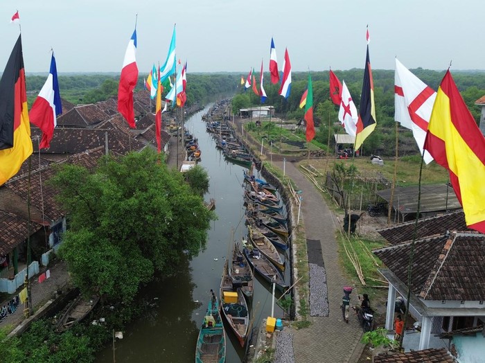 Foto udara sejumlah bendera negara peserta Piala Dunia 2026 berkibar di dermaga Desa Gerongan, Kecamatan Kraton, Kabupaten Pasuruan, Jawa Timur, Jumat (12/6/2026). Warga di desa tersebut mengibarkan bendera negara tim favorit mereka sebagai bentuk dukungan sekaligus menyemarakkan penyelenggaraan Piala Dunia 2026 yang berlangsung pada 11 Juni hingga 19 Juli 2026. ANTARA FOTO/Umarul Faruq/bar