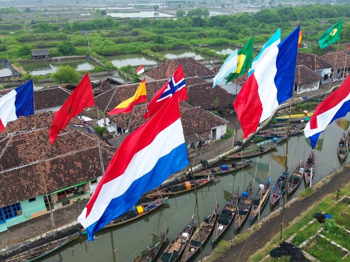 Foto udara sejumlah bendera negara peserta Piala Dunia 2026 berkibar di dermaga Desa Gerongan, Kecamatan Kraton, Kabupaten Pasuruan, Jawa Timur, Jumat (12/6/2026). Warga di desa tersebut mengibarkan bendera negara tim favorit mereka sebagai bentuk dukungan sekaligus menyemarakkan penyelenggaraan Piala Dunia 2026 yang berlangsung pada 11 Juni hingga 19 Juli 2026. ANTARA FOTO/Umarul Faruq/bar