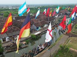 Bagi warga Desa Gerongan, kemeriahan Piala Dunia tidak hanya dirasakan melalui tayangan pertandingan, tetapi juga diwujudkan dalam berbagai bentuk partisipasi sederhana. Deretan bendera yang berkibar di kawasan dermaga menjadi simbol kecintaan masyarakat terhadap sepak bola sekaligus bagian dari perayaan pesta olahraga paling bergengsi di dunia. ANTARA FOTO/Umarul Faruq