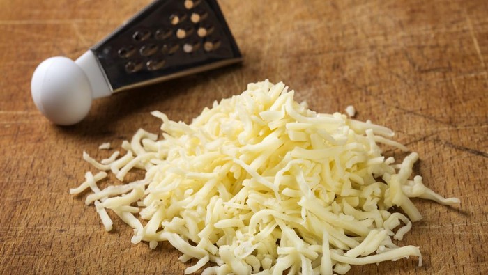 Close up of freshly grated parmesan cheese on wooden table