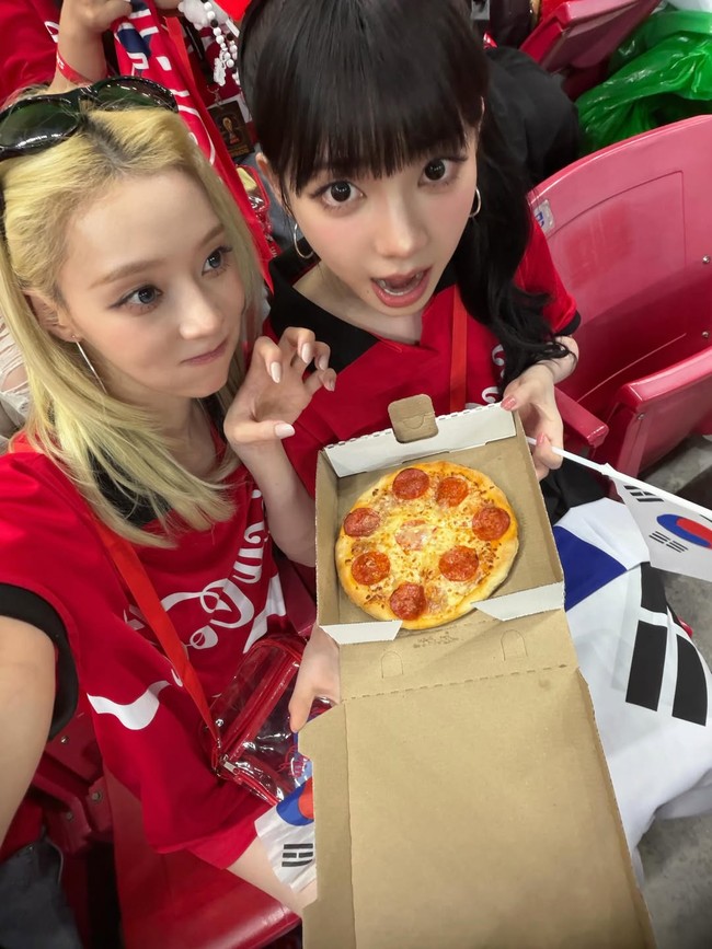 Karina dan Winter aespa kompak memakai jersey Coca Cola yang menjadi sponsor resmi Piala Dunia 2026. Keduanya menikmati pertandingan sembari menyantap pizza dari kursi tribun. Foto: Instagram