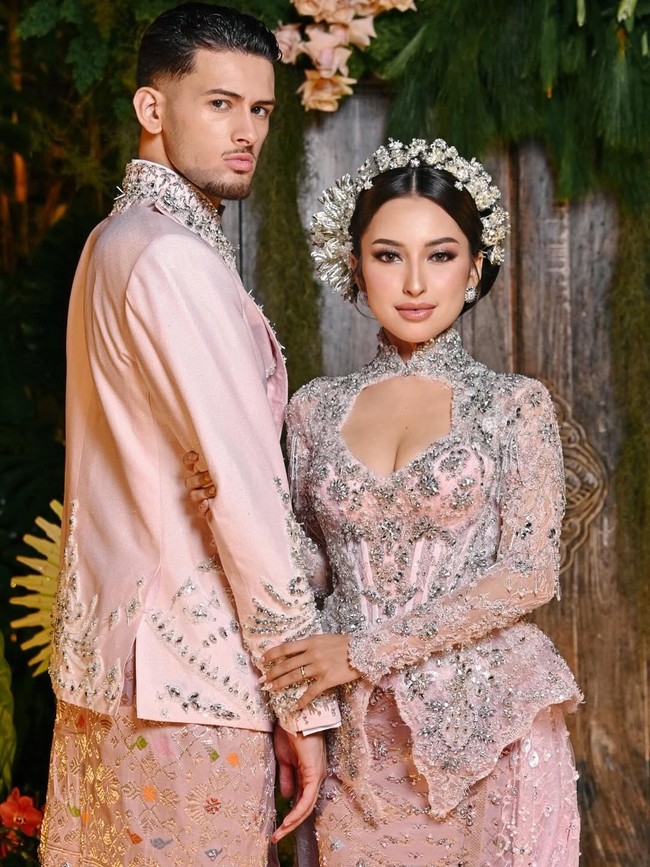 Pilihan warna merah muda dengan aksen silver ini sukses menghadirkan nuansa playful tanpa meninggalkan kesan elegan. Jennifer dan Justin pun membuktikan bahwa tradisi bisa tampil segar dengan interpretasi yang tepat. Sebuah perayaan cinta yang tak hanya hangat, tetapi juga penuh gaya. (Foto: Instagram/@jennifercoppenreal20)