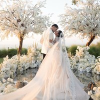 Mengusung konsep ethereal garden wedding, dekorasi tampak begitu mewah dengan begitu banyak bunga-bunga berwarna putih. Aisle atau lorong pengantin dibuat unik dengan berbahan cermin, memantulkan bunga, langit, dan cahaya matahari, sehingga menciptakan efek seolah berjalan di atas air. Foto: Instagram/@jennifercoppenreal20/@justinhubner5