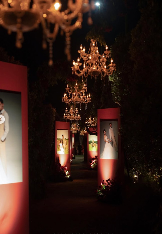 Setelah wedding vows, acara dilanjutkan dengan resepsi berhias dekorasi tak kalah megah serba merah. Untuk dekorasi acara wedding vows dan resepsi Jennifer mempercayakan pada Aisle Project. Area menuju venue dibuat seperti galeri pribadi. Deretan foto prewedding dipasang pada panel-panel merah dengan pencahayaan khusus. Foto: Instagram/@jennifercoppenreal20/@justinhubner5