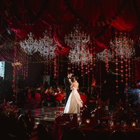 Kali ini dekorasi resepsinyaa berkonsep dramatic red romance. Elemen paling dominan adalah kain merah marun dan merah ruby yang menjuntai memenuhi seluruh plafon. Drapery disusun berlapis-lapis membentuk gelombang dan lipatan dramatis sehingga ruangan terasa seperti tenda kerajaan mewah. Foto: Instagram/@jennifercoppenreal20/@justinhubner5