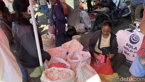 Pedagang bunga di Pasar Galiran Klungkung sedang melayani pembeli, Senin (15/6/2026). (Fatih Kudus Jaelani/detikBali).