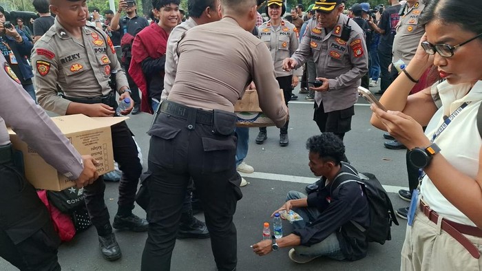Polisi memberikan pelayanan humanis ke massa demo di Silang Monas, berikan roti dan air mineral, Senin (15/6/2026).