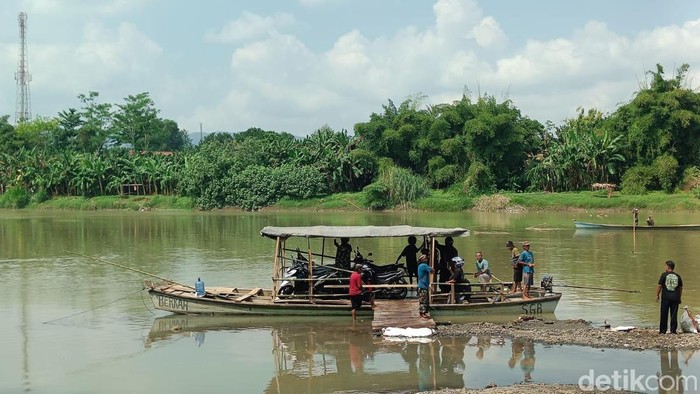 Warga memanfaatkan perahu yang dibuat swadaya oleh masyarakat setempat akibat Jembatan Serayu Banyumas ditutup selama satu setengah bulan untuk perbaikan, Senin (15/6/2026).