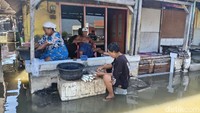 Sejumlha warga tetap beraktivitas melakukan jasa cabut duri ikan. Meski sekitar rumah mereka terendam banjir rob.