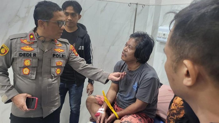 Polisi saat menginterogasi pelaku yang membacok tetangganya hingga tewas