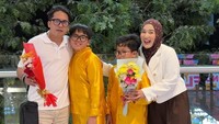 Ririe Fairus tampil anggun mengenakan blazer putih dipadu dengan jilbab motif cokelat, sementara Ayus tampil santai dengan kaos polo putih dan celana krem. Bersama kedua putra mereka, Bian dan Ben, yang kompak mengenakan setelan berwarna kuning emas cerah sambil membawa buket bunga, senyum semringah terpancar jelas dari wajah Ririe. (Foto: dok Instagram ririe_fairus)