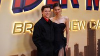 Tom Holland dan Zendaya tampil kompak saat berpose di depan backdrop Spider-Man: Brand New Day. Tom tampak merangkul pinggang sang kekasih dengan mesra, memamerkan senyum lebar mereka ke arah kamera dalam acara yang digelar di Madrid, Spanyol. (Foto: dok Getty Images)