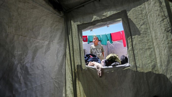 GAZA CITY, GAZA - JUNE 16:  12-year-old Palestinian boy Mohammed Ibrahim Al-Jarjawi sits in tent on June 16, 2026 in Gaza City, Gaza. According to the family of Mohammed Ibrahim Al-Jarjawi, the 12-year-old Palestinian boy suffered the loss of an eye when he was reportedly assaulted during an incident at an Israeli military checkpoint during the war in Gaza in 2024. Mohammed and his family, who have been displaced since their home was destroyed in the war, face difficult conditions living in a tent, as they await medical treatment for him to receive a new artificial eye. (Photo by Ahmad Hasaballah/Getty Images)