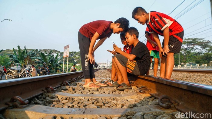 Sejumlah anak memanfaatkan masa libur sekolah dengan bermain di kawasan jalur rel kereta api di Jakarta, Rabu (17/6/2026).