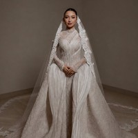 Pada tanggal 14 Juni Jennifer dan Hubner menggelar acara wedding vows. Jennifer tampil santun dengan gaun putih panjang rancangan desainer Christie Basil. Gaun putih berlayer dengan kerah tinggi itu dilengkapi dengan kerudung panjang menerawang. Wajahnya dipulas dengan riasan flawless hasil tangan MUA Leo Afandi. Sementara rambutnya tertata rapi dengan model sanggul sleek yang membuat penampilannya terlihat clean. Foto: Instagram/@bychristiebasil