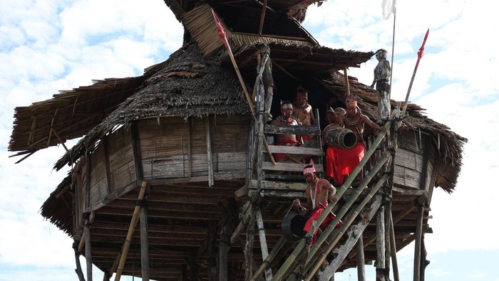 Seorang pria Suku Dayak Bidayuh mengayunkan tongkat bendera setelah berhasil mencapai puncak bambu usai beratraksi panjat bambu terbalik pada pelaksanaan Gawai Nyobeng atau Nibakng di Dusun Sebujit Baru, Desa Hlibuei, Kecamatan Siding, Kabupaten Bengkayang, Kalimantan Barat, Senin (15/6/2026). Atraksi yang menampilkan ketangkasan, kekuatan fisik, dan keseimbangan tersebut menjadi salah satu bagian dari rangkaian perayaan adat sebagai wujud pelestarian budaya masyarakat Dayak Bidayuh. ANTARA FOTO/Jessica Wuysang/bar