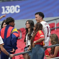 Usai tertunduk lesu karena Spanyol tak berhasil menang pada pertandingan di Grup H Piala Dunia 2026, Lamine Yamal bisa tersenyum lagi berkat dukungan dari keluarga, sahabat dan kekasih yang hadir di tribun penonton di Stadion Mercedes-Benz, Atlanta, Amerika Serikat. Foto: Getty Images/NurPhoto
