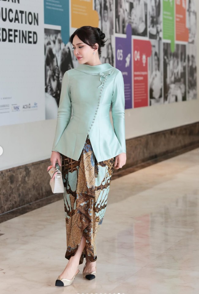 Penampilan Shandy makin memukau dengan rambut bergaya sanggul modern. Beberapa helai rambut dibiarkan membingkai wajah sehingga tampilan tidak terlihat terlalu kaku. Sementara wajahnya dipulas dengan riasan soft glam yang natural. Foto: Instagram/@shandyaulia