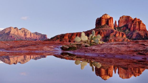 Refleksi batu katedral di kolam hujan di Sedona,