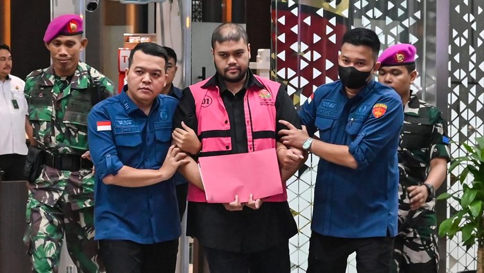 Tersangka kasus dugaan tindak pidana korupsi tata kelola program Makan Bergizi Gratis (MBG) Glory Harimas Sihombing (tengah) berjalan menuju mobil tahanan di Kejaksaan Agung, Jakarta, Kamis (18/6/2026). Kejagung menetapkan satu orang tersangka baru d