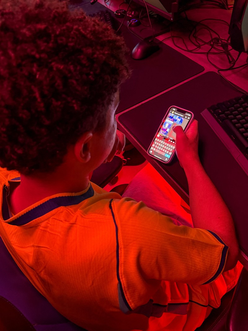 A boy looks at his mobile phone at a gaming centre, after the United Arab Emirates approved a resolution setting the minimum age for social media use at 15, in Dubai, United Arab Emirates, June 18, 2026. Picture taken with a mobile phone. REUTERS/Rula Rouhana