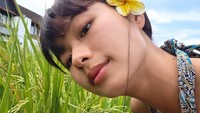 Christy Gardena mengambil gaya selfie di dekat rimbunnya batang padi. Kecantikan alaminya terpancar sempurna tanpa riasan yang berlebihan. Tatapan matanya meneduhkan. (Foto: dok Instagram christygardenaa)