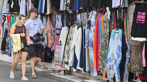 Wisatawan mancanegara melihat produk UMKM saat berwisata di Kuta, Badung, Bali, Jumat (19/6/2026). Kementerian Pariwisata mencatat devisa sektor pariwisata pada triwulan I 2026 mencapai Rp68,28 triliun atau tumbuh 6,3 persen dibandingkan periode yang sama pada 2025 yang didorong oleh bertambahnya jumlah kunjungan wisatawan serta naiknya rata-rata pengeluaran wisatawan mancanegara. ANTARA FOTO/Fikri Yusuf/tom.