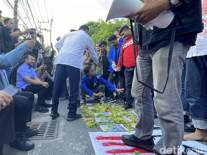 Mahasiswa peserta aksi di Banjarmasin tabur bunga di atas foto 11 anggota DPR RI Dapil Kalsel.
