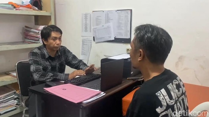 Polisi memeriksa pelaku penikaman (kanan) yang ditangkap setelah setahun buron.