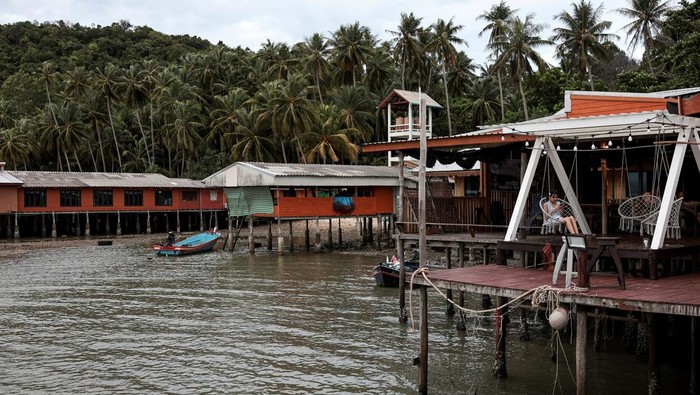 A woman rests on a balcony of an eco-homestay on Koh Phitak Island, in Chumphon province, Thailand, May 17, 2026. REUTERS/Chalinee Thirasupa