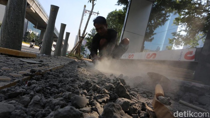 Para pekerja menyelesaikan tahap akhir revitalisasi jalur pedestrian sisi timur Jalan H.R. Rasuna Said, Jakarta Selatan, Jumat (19/6/2026).