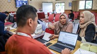 Petugas sekolah melayani proses pemeriksaan berkas calon murid.