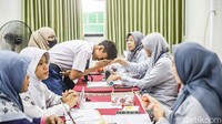 Calon murid bersama orang tua mengantre di Posko Sistem Penerimaan Murid Baru (SPMB) SMKN 12 Tanjung Priok, Jakarta Utara, Jumat (19/6/2026). Mereka melakukan lapor diri dan verifikasi data setelah dinyatakan lolos seleksi.