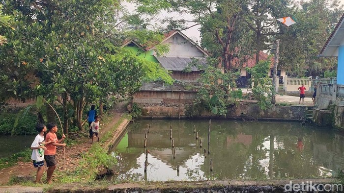 Anak-anak di Rancatunjung Ciamis terlihat sedang berburu layangan putus di sekitar kolam.