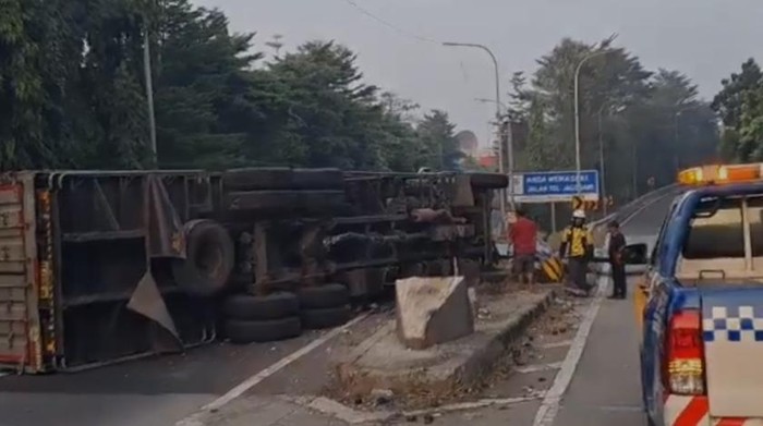 Kecelakaan truk terjadi di Tol Jagorawi, menabrak pembatas dan terguling. (dok.TMC Pold Metro Jaya)