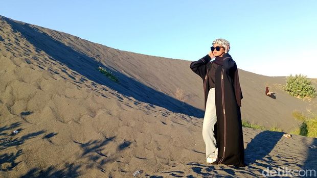 Salah seorang pengunjung berfoto di gundukan pasir bekas tambang di Pantai Dedalpak Desa Pohgading, Kecamatan Pringgabaya, Lombok Timur, NTB, Sabtu (20/6/2026). (Foto: Sanusi Ardi W/detikBali)