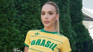 Pasangan Bruno Guimarães, Ana Lídia Martins memadukan jersey crop top dan jeans bergambar tema Brasil yang penuh warna. Foto: Instagram
