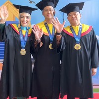 Rona bahagia terpancar jelas dari wajah Ashanty, Azriel, dan Anang Hermansyah saat mereka kompak melambaikan tangan ke arah kamera dalam balutan toga Universitas Airlangga. Foto: Dok. Instagram @ashanty_ash.