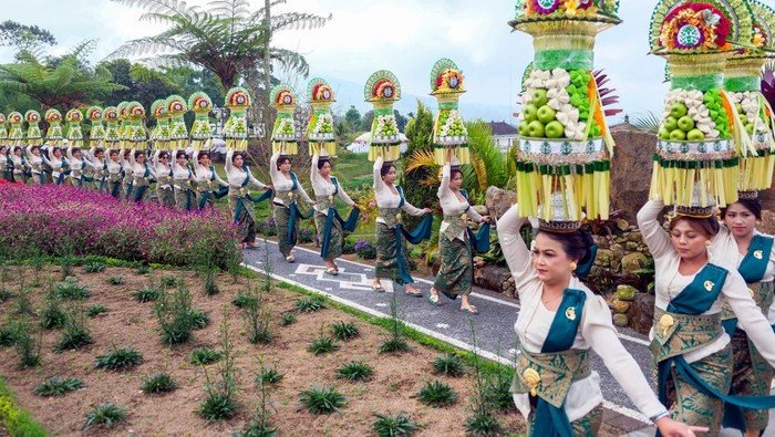 Warga berjalan menjunjung gebogan atau sesajen berisi buah, bunga, dan hiasan janur saat parade seni budaya di The Blooms, Tabanan, Bali, Minggu (21/6/2026). Kegiatan yang digelar pada 21 Juni hingga 9 Agustus 2026 tersebut menampilkan seni budaya kearifan lokal dengan melibatkan 1.500 warga dari 20 desa sebagai promosi pariwisata untuk meningkatkan jumlah kunjungan wisatawan. ANTARA FOTO/Nyoman Hendra Wibowo