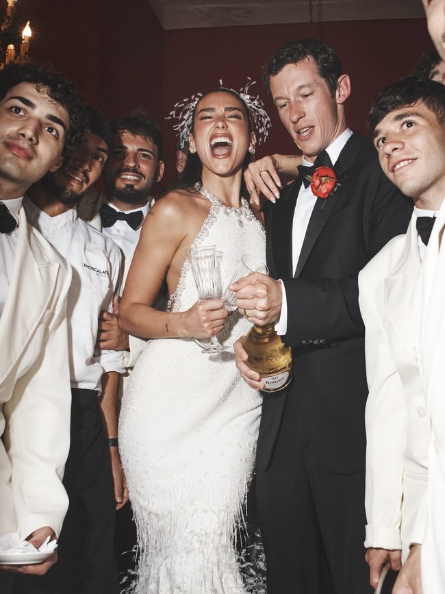 Selain menampilkan detail gaunnya, Dua Lipa juga membagikan beberapa foto yang memperlihatkan suasana intim pernikahan mereka. Salah satunya potret dirinya berdiri di bawah lengkungan bangunan khas Italia, sementara foto lain memperlihatkan veil panjangnya menjuntai indah saat berpose bersama Callum Turner. Foto: Instagram/@dualipa