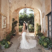 Siluetnya menampilkan potongan punggung rendah, lengkap dengan ekor gaun panjang yang dihiasi bulu-bulu. Penampilannya semakin dramatis berkat veil bordir panjang dan hiasan kepala berbulu. Foto: Instagram/@dualipa