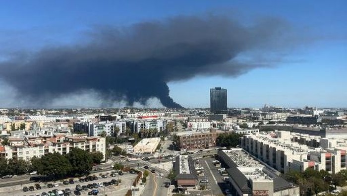 Black smoke rises from a warehouse fire in Boyle Heights as seen from downtown Los Angeles on June 17, 2026. The Los Angeles Fire Department issued a shelter-in-place order for Boyle Heights due to Hazardous materials after a fire at a storage facili