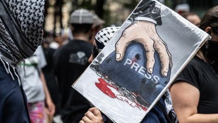 NEW YORK, NEW YORK - AUGUST 16: A person carries a sign referring to the recent killings of the Al Jazeera journalists as Pro-Palestinian protesters participate in a March for Humanity against the humanitarian crisis in Gaza on August 16, 2025 in N