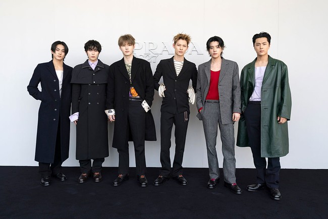 Ada Jungwon dan Sunoo yang berbalut coat hitam, Jake tampil nyentrik dengan setelan jas abu-abu dan atasan merah. Personel termuda Ni-ki memakai setelan jas dan atasan bermotif stripes, Jay dengan coat berwarna emerald green, serta Sunghoon memakai atasan abstrak dan coat serupa. Foto: Getty Images for Prada/Jacopo Raule