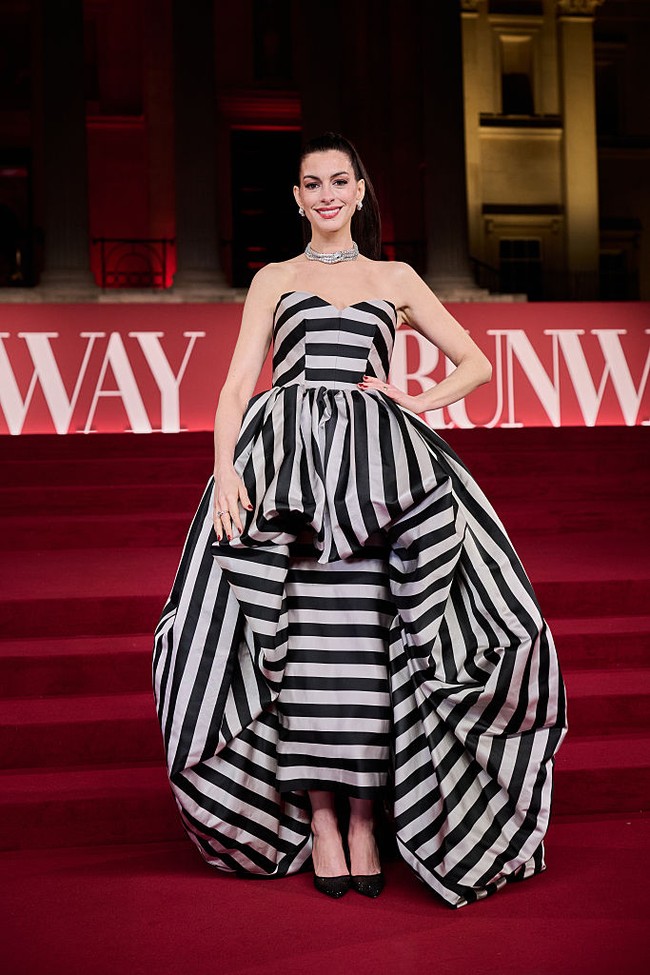 Masih di momen berdekatan, Anne memilih gaun motif garis Louis Vuitton. Detail ruffle bervolume di bagian perut, pinggang hingga menjuntai ke bawah memberi kesan dramatis. Foto: Gareth Cattermole/Getty Images/Gareth Cattermole