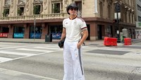 Berdiri tegap di penyeberangan jalan, Atta Halilintar memamerkan gaya OOTD secara penuh. Ia kali ini tampil dengan jersey Timnas Spanyol bernuansa putih-merah dengan sepatu bersol tebal. Topi koboi hitam tetap menjadi statement piece utamanya. (Foto: dok Instagram attahalilintar)