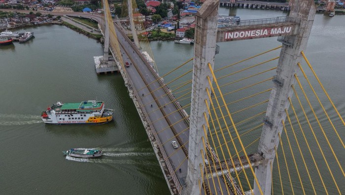 Foto udara kapal fery KMP Bahteramas melintasi Jembatan Teluk Kendari di Teluk Kendari, Sulawesi Tenggara, Senin (22/6/2026). Kementerian Perhubungan kembali memberikan diskon tarif lintas moda transportasi 30 persen untuk kelas ekonomi selama libur sekolah 2026 guna meningkatkan mobilitas dan daya beli masyarakat, mendukung pariwisata serta mendorong pertumbuhan ekonomi daerah. ANTARA FOTO/Andry Denisah/wsj.