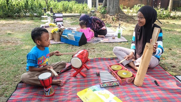 Anak didampingi orang tuanya mencoba permainan tradisional saat Festival Dolanan Bocah 2026 di Dalem Joyokusuman Solo, Jawa Tengah, Minggu (21/6/2026). Acara tersebut digelar sebagai ruang bermain sekaligus belajar yang memperkenalkan nilai kebersamaan, kreativitas, dan warisan budaya kepada generasi muda. ANTARAFOTO/Maulana Surya/YU *** Local Caption ***