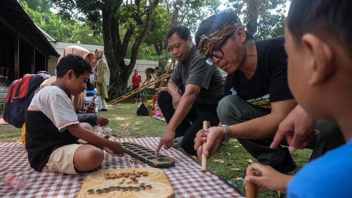 Anak didampingi orang tuanya mencoba permainan tradisional saat Festival Dolanan Bocah 2026 di Dalem Joyokusuman Solo, Jawa Tengah, Minggu (21/6/2026). Acara tersebut digelar sebagai ruang bermain sekaligus belajar yang memperkenalkan nilai kebersamaan, kreativitas, dan warisan budaya kepada generasi muda. ANTARAFOTO/Maulana Surya/YU *** Local Caption ***