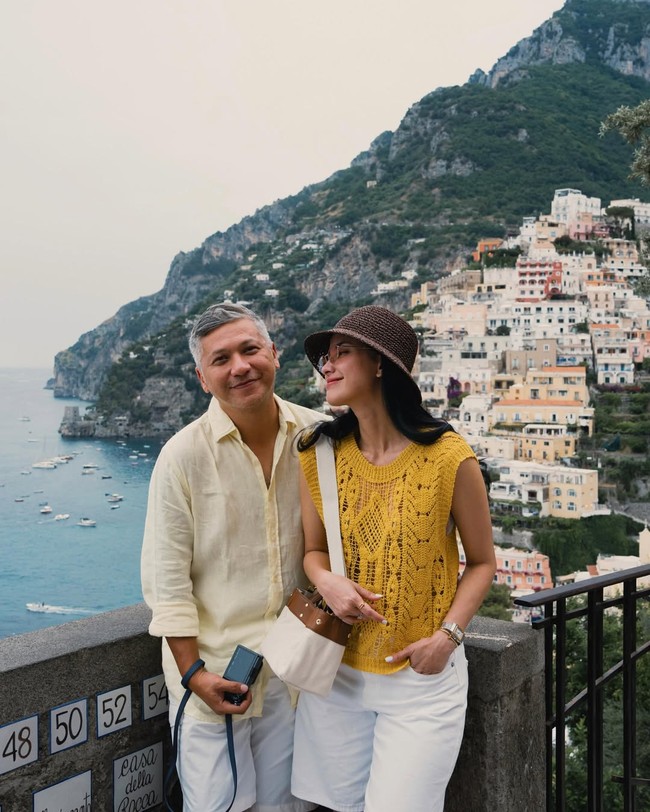 Saat menikmati suasana indah Positano di Amalfi Coast, Italia, Gading Marten dan Medina Dina memilih padu padan warna cerah yang menyegarkan. Celana putih dipadukan dengan atasan bernuansa kuning menciptakan tampilan yang ringan, elegan, sekaligus cocok dengan latar pantai Mediterania yang menawan. Foto: dok Instagram gadiiing / abiismail